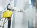 Proceso de quitar pintura de metal con pistola de chorro de arena.