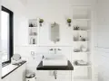 Modern bathroom with a white rectangular lavabo sobre mueble de madera oscura. Estanterías blancas a los lados.