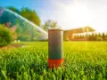 Aspersor de césped en acción, mostrando diferentes tipos de aspersores para riego eficiente bajo el sol.