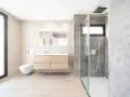 Baño moderno con ducha de cristal, lavabo flotante y WC suspendido. La fontanería se integra con estilo, cuidando cada altura y medida.