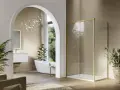 Mampara de ducha moderna con perfil dorado, un ejemplo de los tipos de mamparas de ducha que combinan estilo y funcionalidad en un baño elegante.