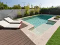 Modern pool with deck, lounge chairs, and bamboo plants. Great ideas para decorar alrededor de la piscina para un oasis de verano.