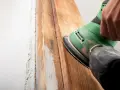 Lijando madera para quitar barniz viejo. El proceso de como quitar barniz de la madera se ve en acción con una lijadora.
