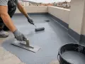 Aplicación de impermeabilizante para terrazas con rodillo y llana. Protegiendo la superficie contra la humedad.