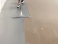 Aplicando pintura epoxi gris sobre un suelo de hormigón. El proceso de aplicación de la pintura epoxi transforma el espacio.
