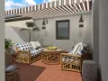 Cómodos sillones de mimbre con cojines a cuadros, mesa de centro con frutas, y un toldo a rayas. ¡Perfectas ideas de jardín para relajarse!
