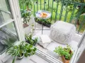 Acogedor rincón en unas terrazas pequeñas con encanto: cojines, plantas, un libro y cruasanes para un desayuno perfecto.