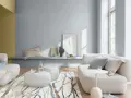 Salón moderno con sofás blancos, alfombra de ramas y paredes en pintura al agua gris y ocre.