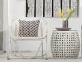 Sillón y mesa auxiliar de mimbre blanco, con cojín estampado y flores amarillas. Ideas de colores para pintar mimbre.