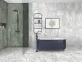 Elegante baño con ducha y bañera azul. Las paredes y el suelo lucen un vinilo para baños sobre azulejos con efecto mármol.