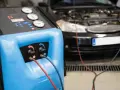 Máquina para cargar gas aire acondicionado conectada a un coche.