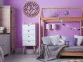 Adolescentes pintan habitación juvenil. Un espacio lleno de color lila, con cama de madera, cómoda blanca y decoración infantil.