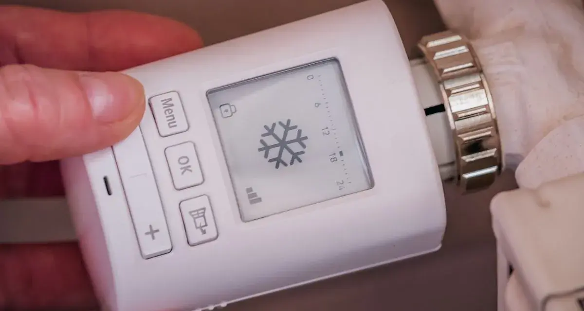 Termostato digital para sistemas de calefacción, con pantalla que muestra un copo de nieve y botones para ajustar la temperatura.