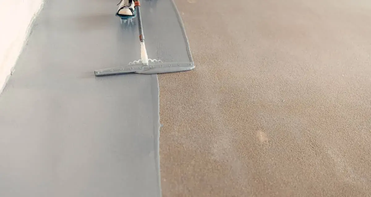 Aplicando pintura epoxi gris sobre un suelo de hormigón. El proceso de aplicación de la pintura epoxi transforma el espacio.