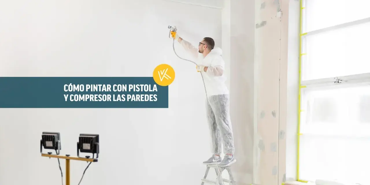 Hombre con traje protector pintando una pared con pistola y compresor.