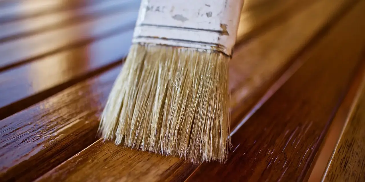 Brocha aplicando barniz a madera. Diferentes tipos de barniz para madera protegen y embellecen.