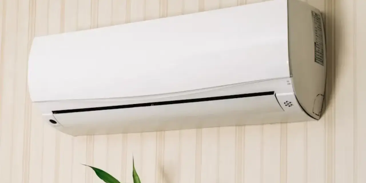 Un aire acondicionado blanco montado en una pared con papel tapiz. Averigua cuanto consume un aire acondicionado para ahorrar energía.