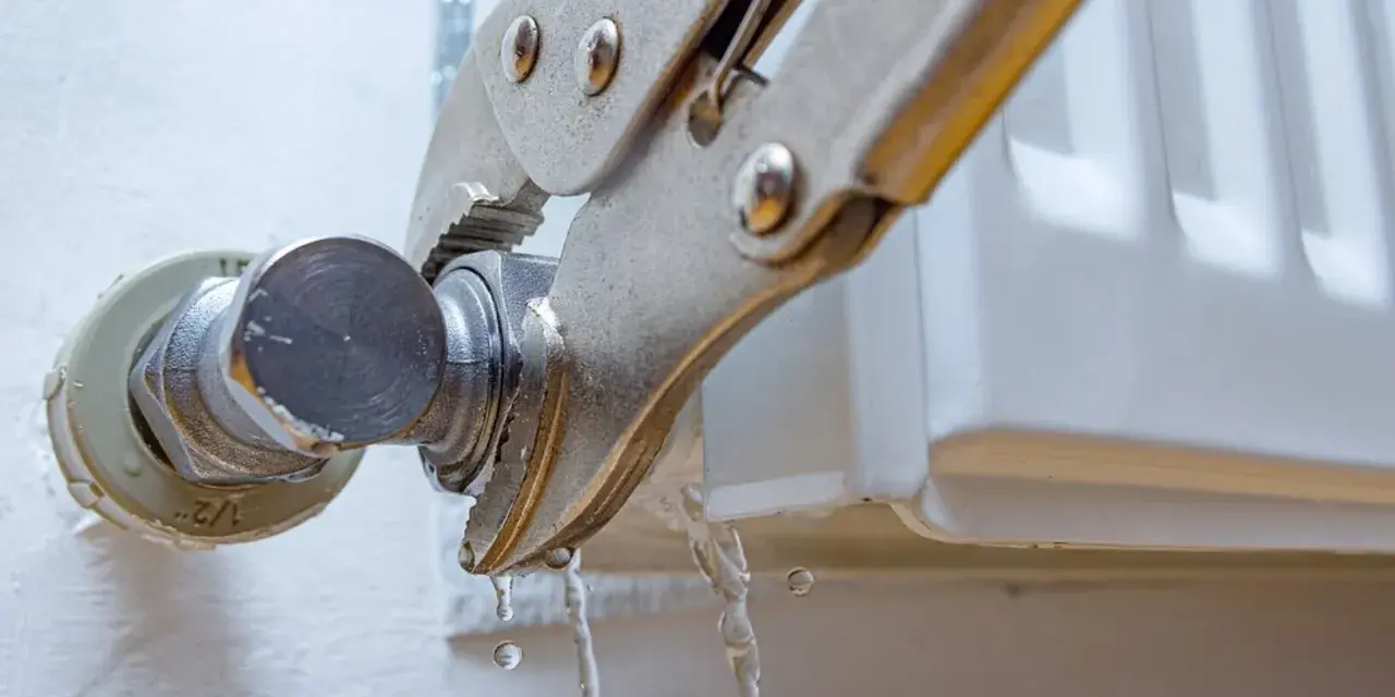 Herramienta sujeta el grifo de un radiador que gotea. Se está intentando cambiar la llave radiador que gotea.