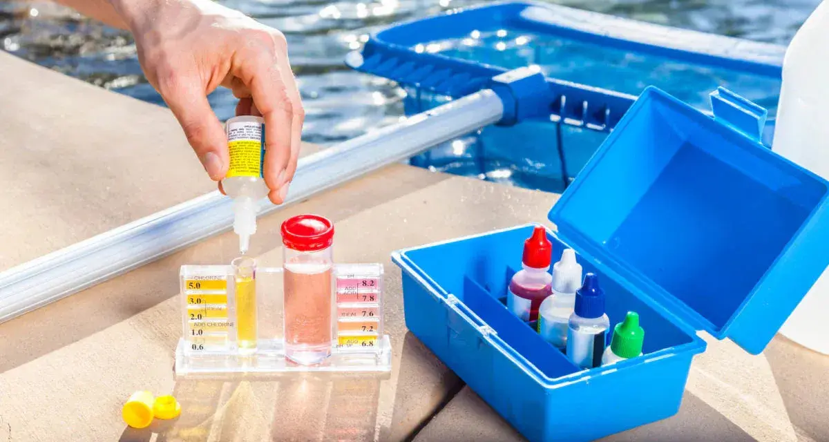 Persona usa un kit para medir el cloro y el pH de la piscina. Se puede echar cloro a una piscina de sal.