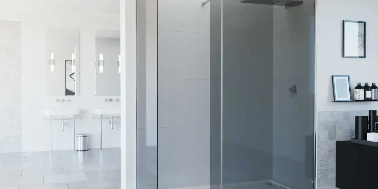 Moderno baño con mampara de ducha de esquina de cristal ahumado, lavabos dobles y accesorios elegantes.