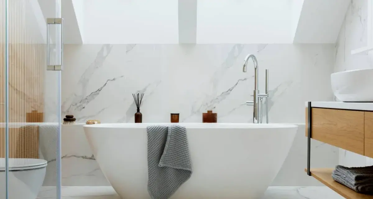 Baño moderno con bañera exenta, grifería cromada y revestimiento de mármol. Ideal para instalar bañera y disfrutar de un oasis de paz.