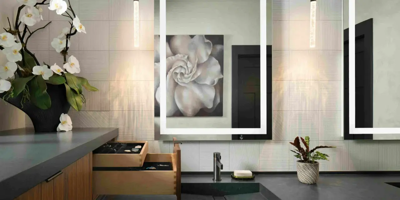 Elegante tocador con espejo iluminado, lavabo empotrado y orquídeas. Ideal para calcular el precio reforma baño 4 m2.