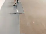 Aplicando pintura epoxi gris sobre un suelo de hormigón. El proceso de aplicación de la pintura epoxi transforma el espacio.