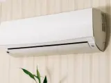Un aire acondicionado blanco montado en una pared con papel tapiz. Averigua cuanto consume un aire acondicionado para ahorrar energía.