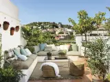 Un espacio perfecto para **chill out** en la **terraza**, con cómodos cojines, plantas y vistas a la ciudad.