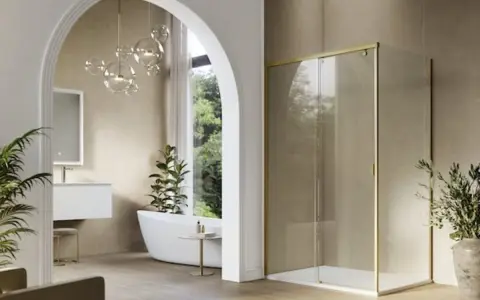 Mampara de ducha moderna con perfil dorado, un ejemplo de los tipos de mamparas de ducha que combinan estilo y funcionalidad en un baño elegante.