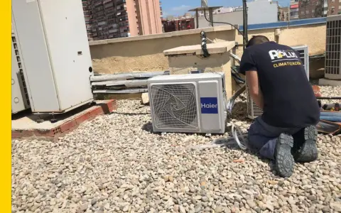 Técnico realizando mantenimiento de aire acondicionado en una azotea. Se ve una unidad Haier y otras unidades de climatización.