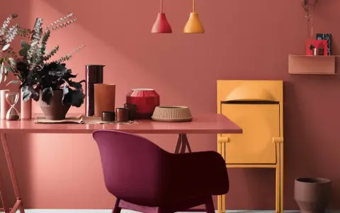 Un espacio moderno con paredes en tono terracota, ideal para inspirarte sobre como pintar paredes y decorar con muebles y objetos en colores vibrantes.