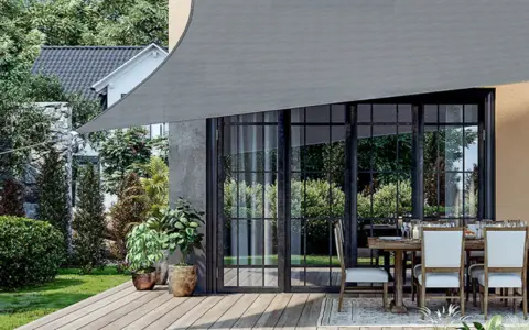Un toldo gris protege un patio con mesa y sillas. Muestra varios tipos de toldos para exteriores, ideales para crear sombra.