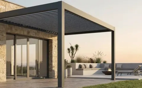 Moderna casa con terraza y **pérgola bioclimática** de lamas orientables. Sofá, tumbonas y hoguera invitan al relax.