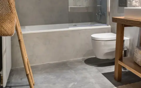 Baño moderno con bañera, inodoro suspendido y lavabo de madera. ¿Cuánto cuesta cambiar bañera por plato de ducha?