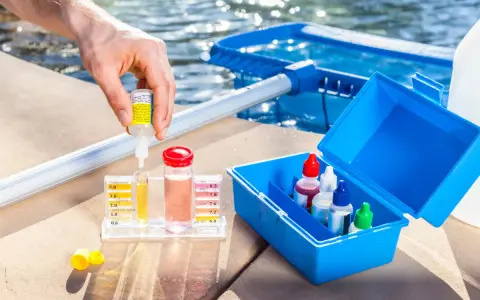 Persona usa un kit para medir el cloro y el pH de la piscina. Se puede echar cloro a una piscina de sal.