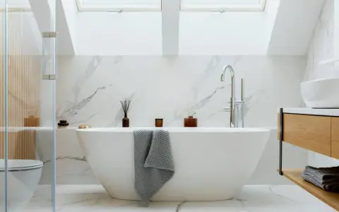 Baño moderno con bañera exenta, grifería cromada y revestimiento de mármol. Ideal para instalar bañera y disfrutar de un oasis de paz.