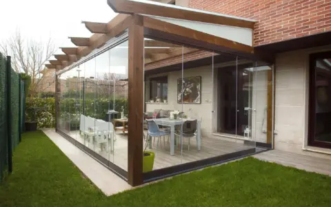 Modernas ideas para cerrar porche con cristaleras, creando un espacio luminoso y funcional con mobiliario de exterior.