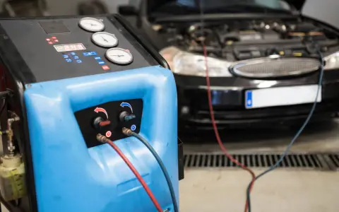 Máquina para cargar gas aire acondicionado conectada a un coche.