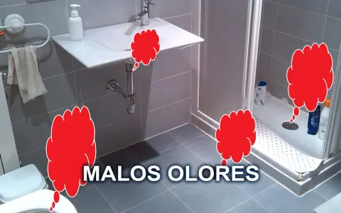 Baño con ducha, lavabo e inodoro. Nubes rojas indican malos olores, sugiriendo un problema con el olor tuberías baño.