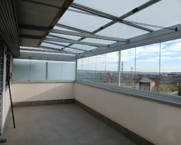 Terraza con diversos tipos de cerramientos: acristalamiento corredero y techo de cristal.