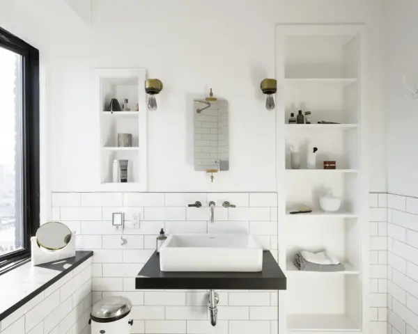 Modern bathroom with a white rectangular lavabo sobre mueble de madera oscura. Estanterías blancas a los lados.