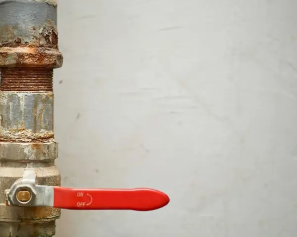 Tubería oxidada con llave de paso roja, lista para cambiar llaves de paso antiguas.
