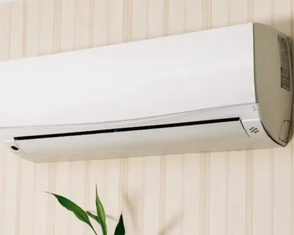 Un aire acondicionado blanco montado en una pared con papel tapiz. Averigua cuanto consume un aire acondicionado para ahorrar energía.