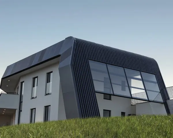 Moderna casa autosuficiente con techo curvo y grandes ventanales, rodeada de hierba alta bajo un cielo despejado.