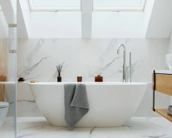 Baño moderno con bañera exenta, grifería cromada y revestimiento de mármol. Ideal para instalar bañera y disfrutar de un oasis de paz.