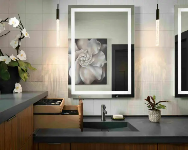 Elegante tocador con espejo iluminado, lavabo empotrado y orquídeas. Ideal para calcular el precio reforma baño 4 m2.