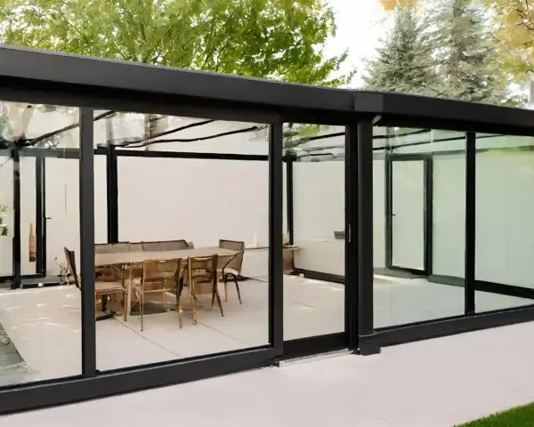 Elegante estructura de cristal para cerrar terraza, con mesa y sillas listas para disfrutar.