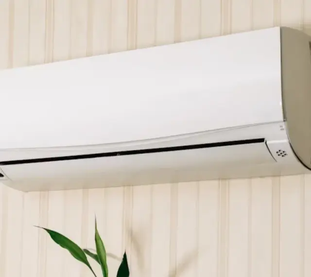 Un aire acondicionado blanco montado en una pared con papel tapiz. Averigua cuanto consume un aire acondicionado para ahorrar energía.
