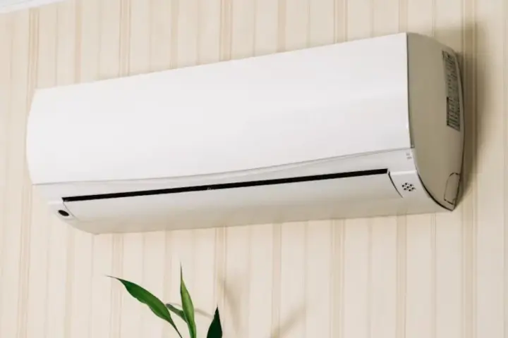 Un aire acondicionado blanco montado en una pared con papel tapiz. Averigua cuanto consume un aire acondicionado para ahorrar energía.